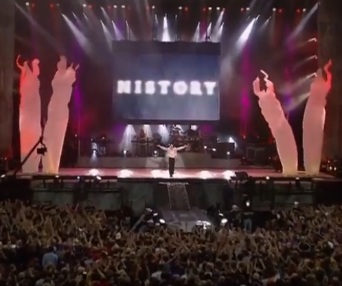 Der King of Pop live auf der Bühne zum Ende seiner Konzerte. HISTORY ist auf der Leinwand hinter ihm zu lesen.