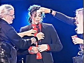 Michael Jackson on stage when makeup and change of clothes is done by his employees. Before the eyes of the audience